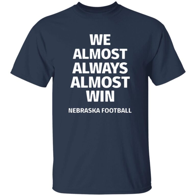 Navy blue t-shirt with white text 'WE ALMOST ALWAYS ALMOST WIN NEBRASKA FOOTBALL' on a white background